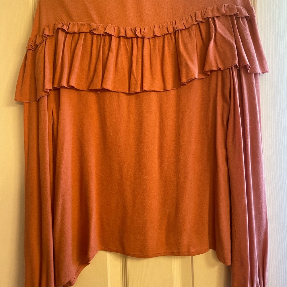 Leigh Blouse v-neck, ruffled front & back. 100% viscose, elastic wrist.